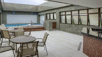 Una piscina al aire libre, sombrillas, tumbonas