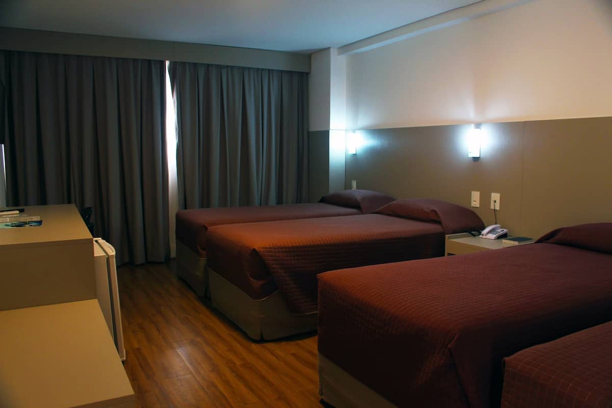 Une chambre d’hôtel avec deux lits, un bureau et un téléphone.