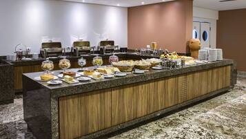A buffet setup with various food items and serving equipment.
