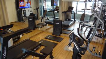 A gym with treadmills, exercise bikes, and weight machines.