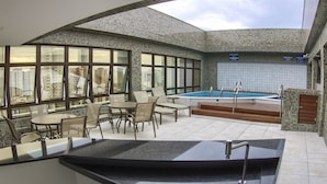 A modern outdoor pool area with a bar and seating. - Marante Executive Hotel (Recife)