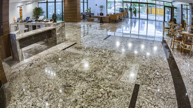 A spacious lobby with a marble floor, seating area, and large windows offering a view of the outside. - Marante Executive Hotel (Recife)