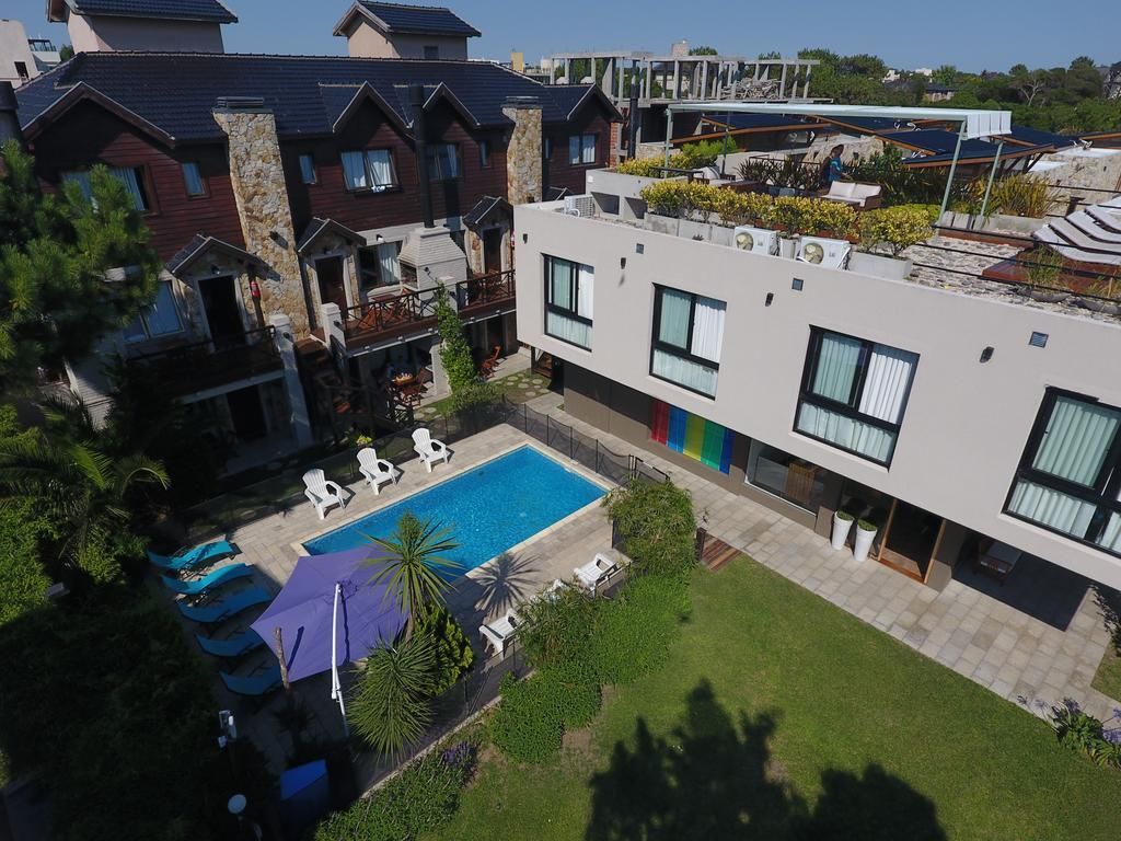 Um edifício residencial moderno com piscina, área de estar externa e jardim bem cuidado.