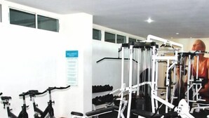 A gym with exercise bikes, weight machines, and a treadmill. - Apartamentos Morros 427 Cartagena (Cartagena)