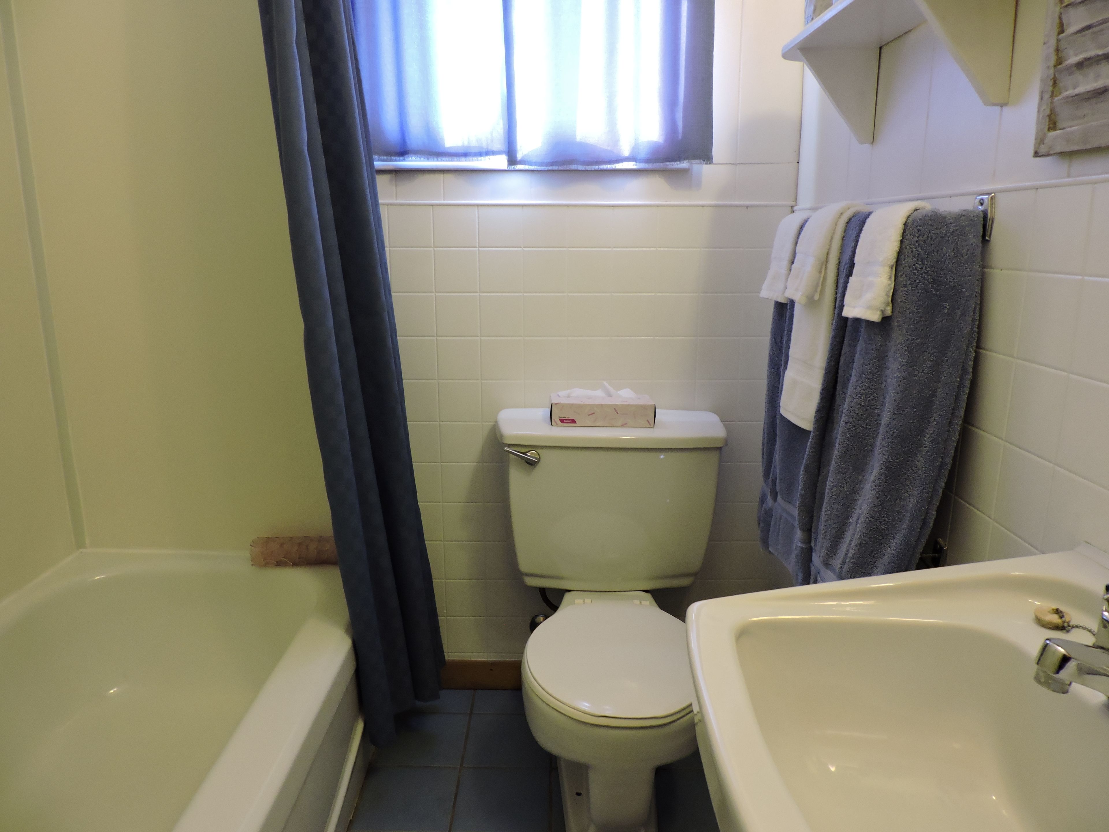 A small bathroom with a toilet, a bathtub, and a sink.
