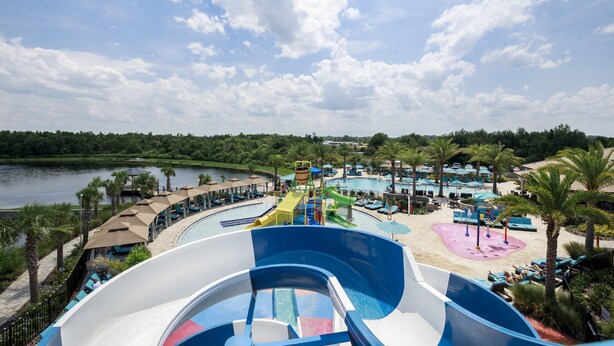 A water park with a large wave pool, lounge areas, and a view of the lake.