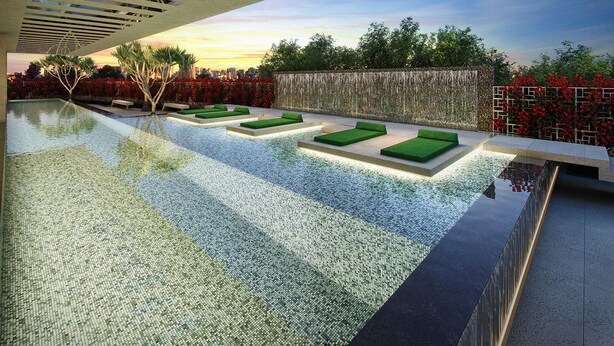 A modern infinity pool with green loungers, a stone wall, and a cityscape view at sunset. - VN Turiassu Studio 805 (São Paulo)