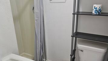 A bathroom with a shower, toilet, and sink.