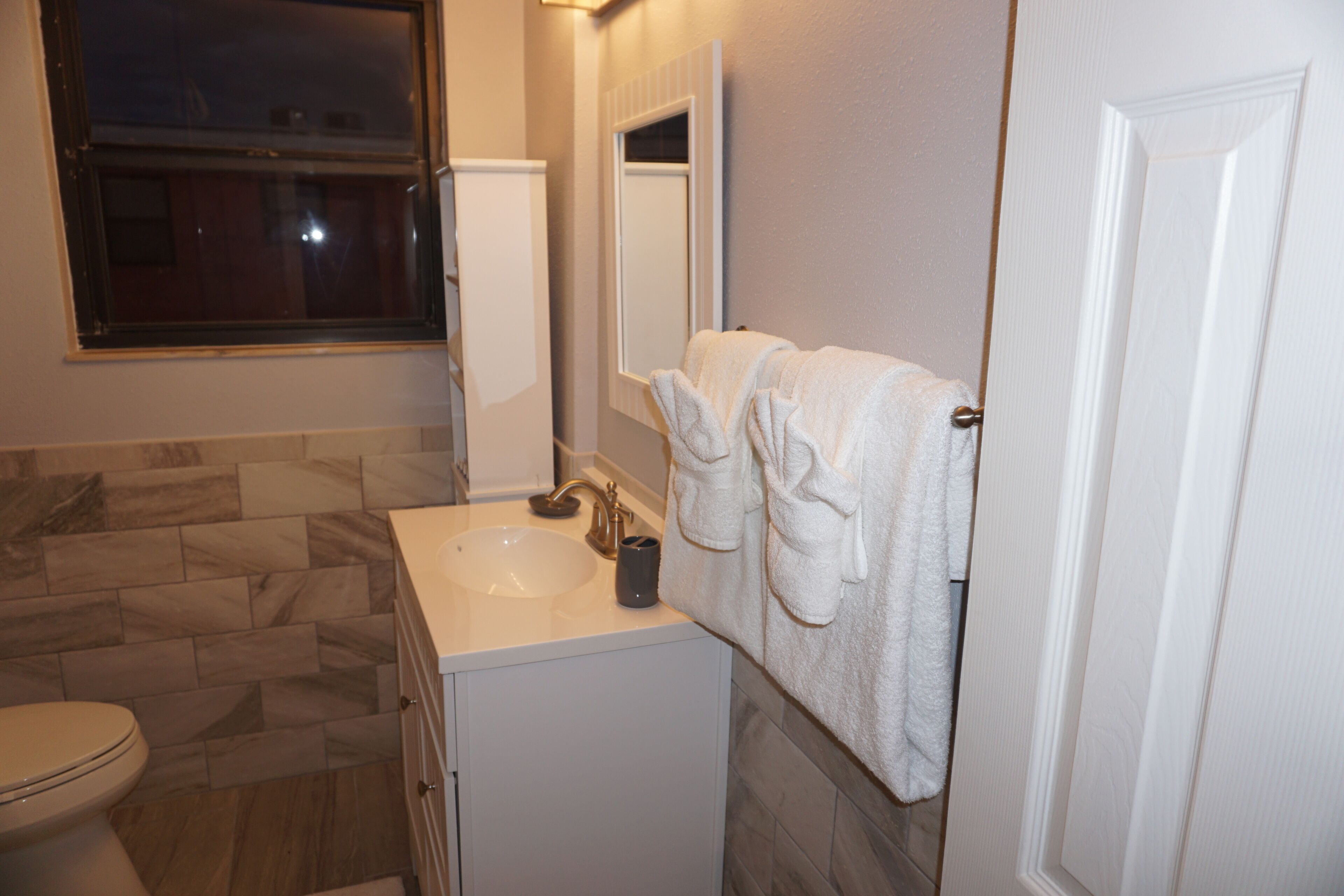 A bathroom with a toilet, sink, and towel rack.