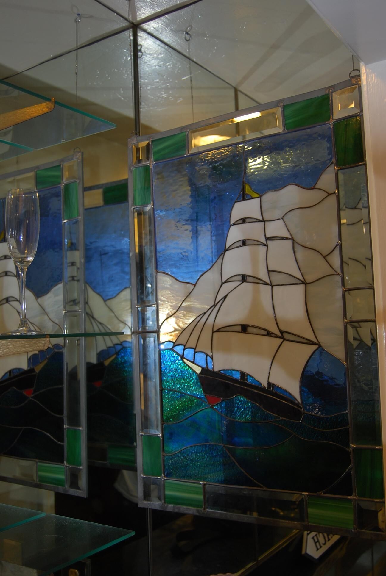 Een glas-in-loodraam met een ontwerp van een zeilboot.