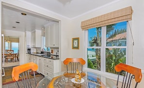 A dining area with a glass table, two chairs, and a decorative centerpiece.