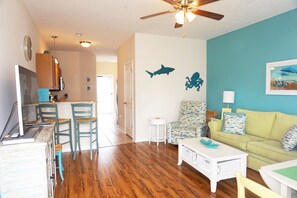 Relax in this open-plan living space with a kitchen area, dining table, and comfortable sofa.