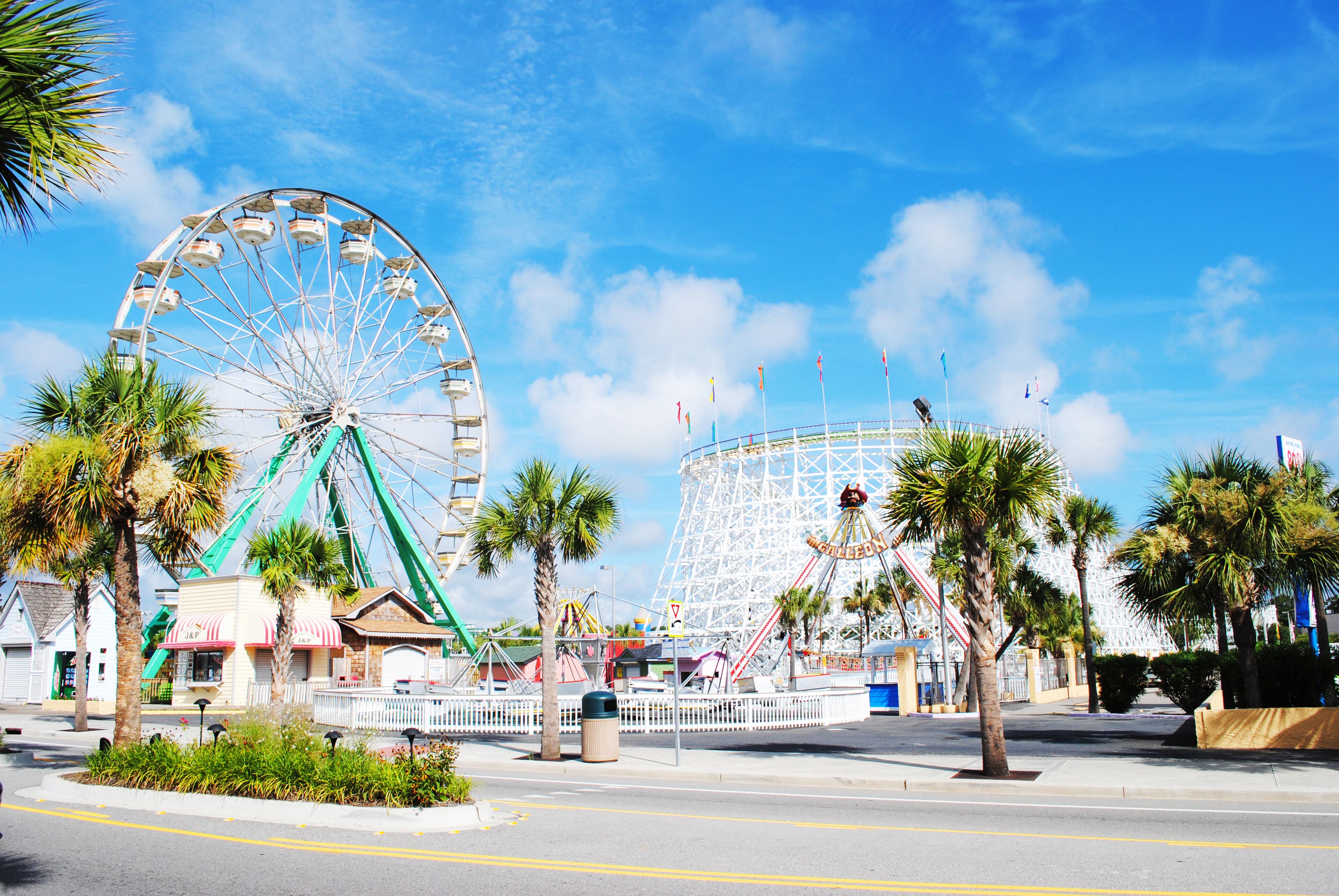 A Ferris wheel and a roller coaster at an amusement park.