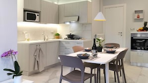 A modern kitchen with a dining area, featuring a microwave, stove, and oven.