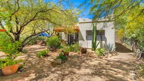 A garden with various plants and a small building with a door and windows. - Private Southwestern Style Casita with Lush & Fully fenced Lush Yard** (Tucson)