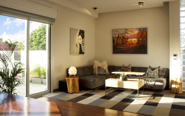 A modern living room with a sofa, coffee table, and artwork on the walls.