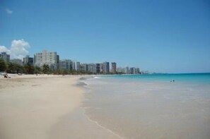 A beach with a city skyline in the background.