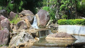 Eine natürliche Felsformation mit einem kleinen Wasserfall und einem Teich.