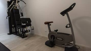 Un gimnasio en casa con una elíptica y una máquina de pesas.