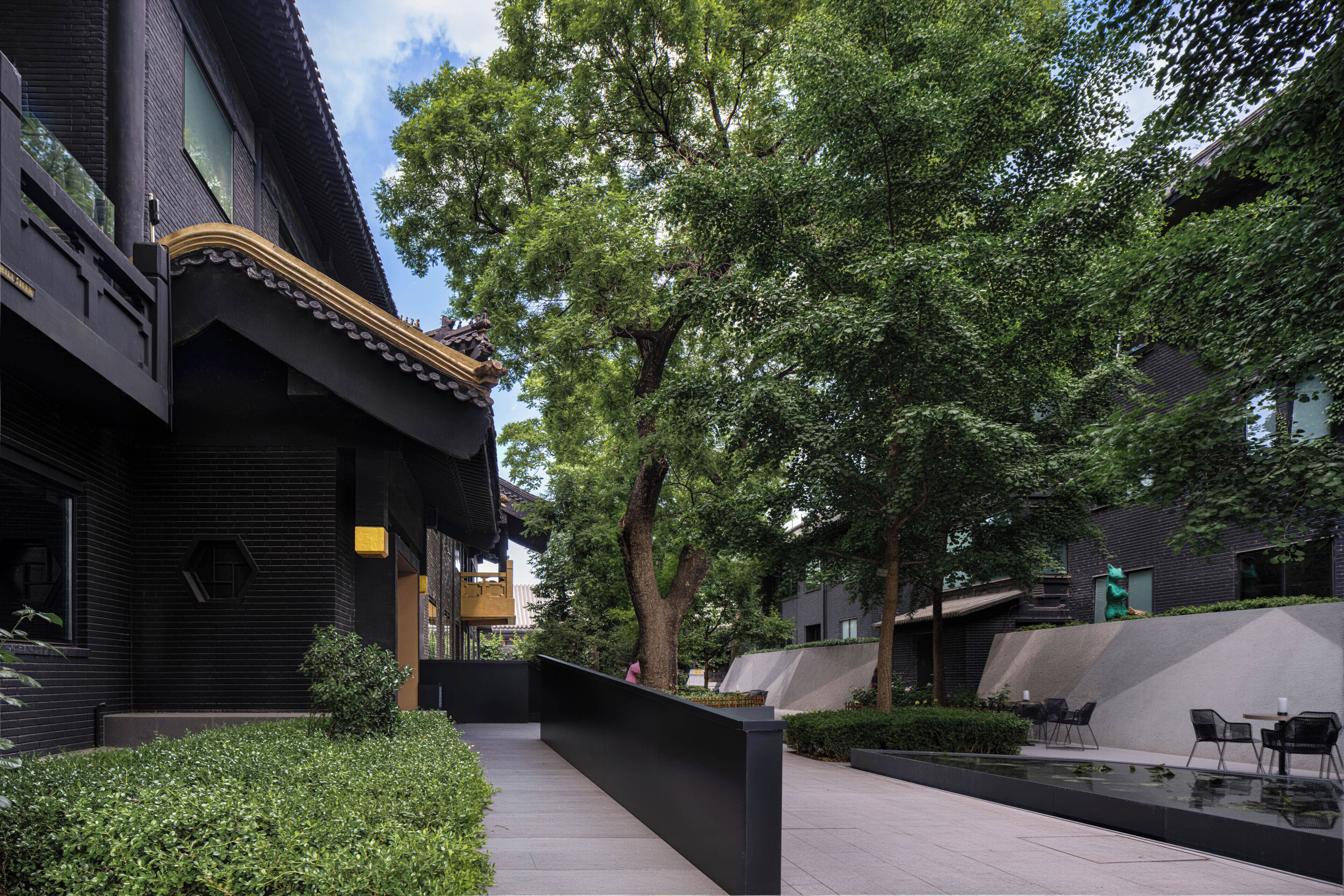A courtyard with a water feature, seating area, and traditional architecture.