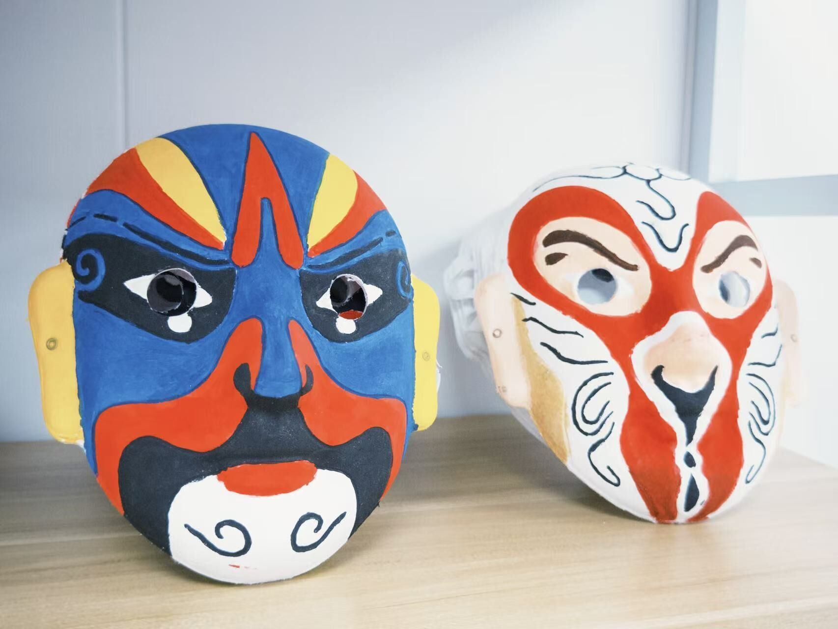 Dos máscaras tradicionales con colores y diseños llamativos.