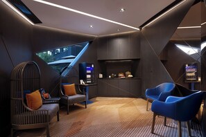 A modern interior with a seating area, a built-in TV, and a small kitchenette. - Blossom House Prince Kung's Mansion · Beijing Houhai (Beijing)