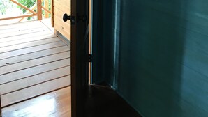 A wooden door with a metal handle and a white decorative element. - Maya Hill Lodge (Mount Hope)