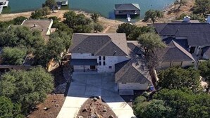 An aerial view of a residential area with houses, a dock, and a body of water.
