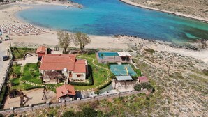 Una propiedad costera con playa, cancha de tenis y piscina.