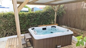 A hot tub in a wooden deck area with a pergola overhead. - Typical Algarve House - Fuzeta, Arrroteia "Casas carpinteiro" (Tavira)