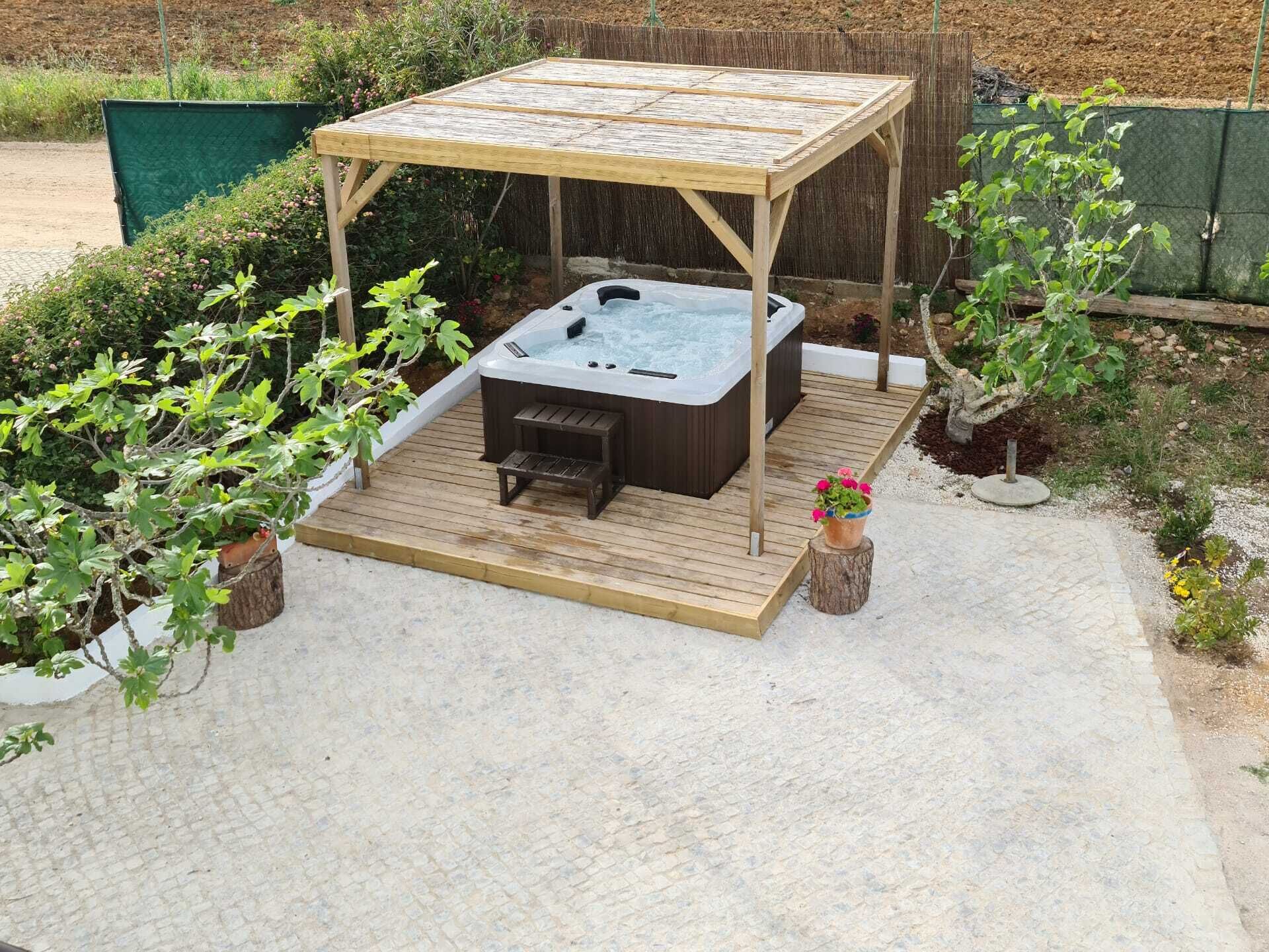 Un bain à remous doté d’une terrasse en bois et surmonté d’une pergola.