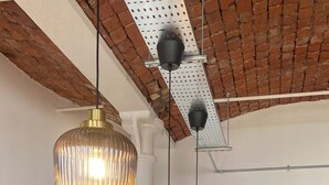 Un comedor con una mesa de madera oscura, sillas de fibra y lámparas colgantes con diseño acanalado.