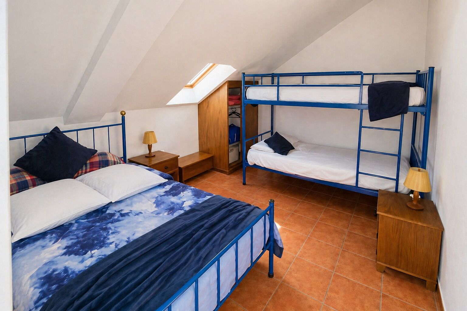 Une chambre de dortoir équipée de lits superposés, d’un bureau, d’une chaise, d’une lampe et d’une armoire.
