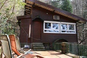 A wooden cabin with a large window, a porch with chairs, and a stone staircase leading to the entrance. - Something special for nature lovers with a wonderful distant view (Offenburg)