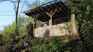 A stone building with a metal roof and a balcony.