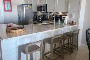 A kitchen with a central island, stainless steel appliances, and a modern faucet.