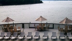 A poolside area with lounge chairs and umbrellas, overlooking a body of water.