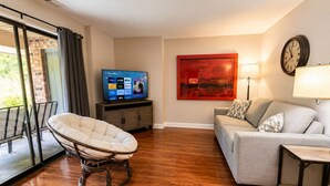 A living room with a sofa, a chair, a TV, and a painting on the wall. - Steps to Lakefront Park. Close to Town, Waterslides, Wineries, and Golf Courses. (Chelan)