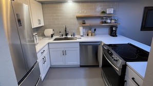 A modern kitchen with stainless steel appliances, white cabinetry, and a tiled backsplash. - Steps to Lakefront Park. Close to Town, Waterslides, Wineries, and Golf Courses. (Chelan)