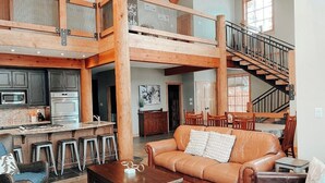 A spacious loft-style living area with a kitchen, a dining area, and a staircase leading to an upper level. - Hiking,biking,skiing, family reunion or trip to a national park we have it all!! (Golden)