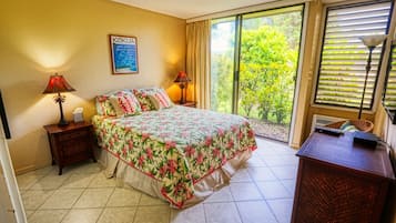 A bedroom with a bed, two nightstands, a desk, a window with blinds, and a poster on the wall.