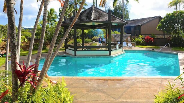 A swimming pool with a gazebo, palm trees, and a house in the background. - Turtle Bay  - Relax In Paradise 570010290183/CCH-0111 (Kahuku)