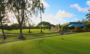 Stroll along the well-manicured golf course to the clubhouse, surrounded by lush greenery.