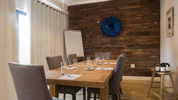 A conference room with a wooden wall, a blue decorative item, and a whiteboard.