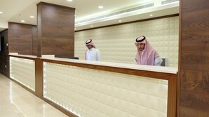 Un mostrador de recepción con detalles de madera y un respaldo blanco acolchado.