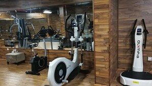 Un gimnasio con equipo de ejercicio, incluyendo una bicicleta estática y una cinta de correr.