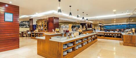 A modern hotel lobby with a central reception desk, wooden accents, and a polished floor.