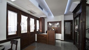 A spacious room with a wooden desk, a chair, and a cabinet. - Hotel Teatar (Bitola)