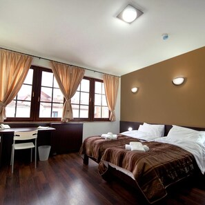A hotel room with a bed, a desk, a chair, and a window with curtains. - Hotel Teatar (Bitola)