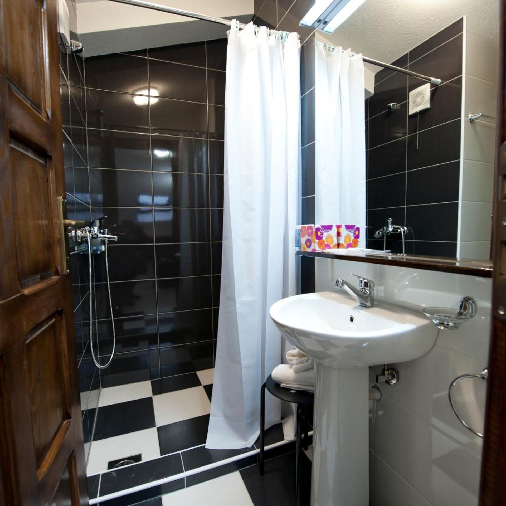 A bathroom with a shower, a sink, and a mirror.
